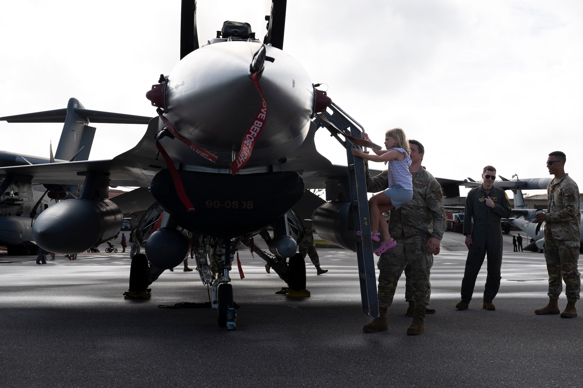 A girl climbs into an F-16 Fighting Falcon stationed at Misawa Air Base, Japan during the Cope North 24 static display on Andersen Air Force Base, Guam, Feb. 22, 2024. The static display gave military personnel and families a look at aircraft that had been used during Cope North 24. Exercises like Cope North 24 enable the Joint and combined forces to validate new ways to deploy, maneuver and test new assets. (Airman 1st Class Spencer Perkins)