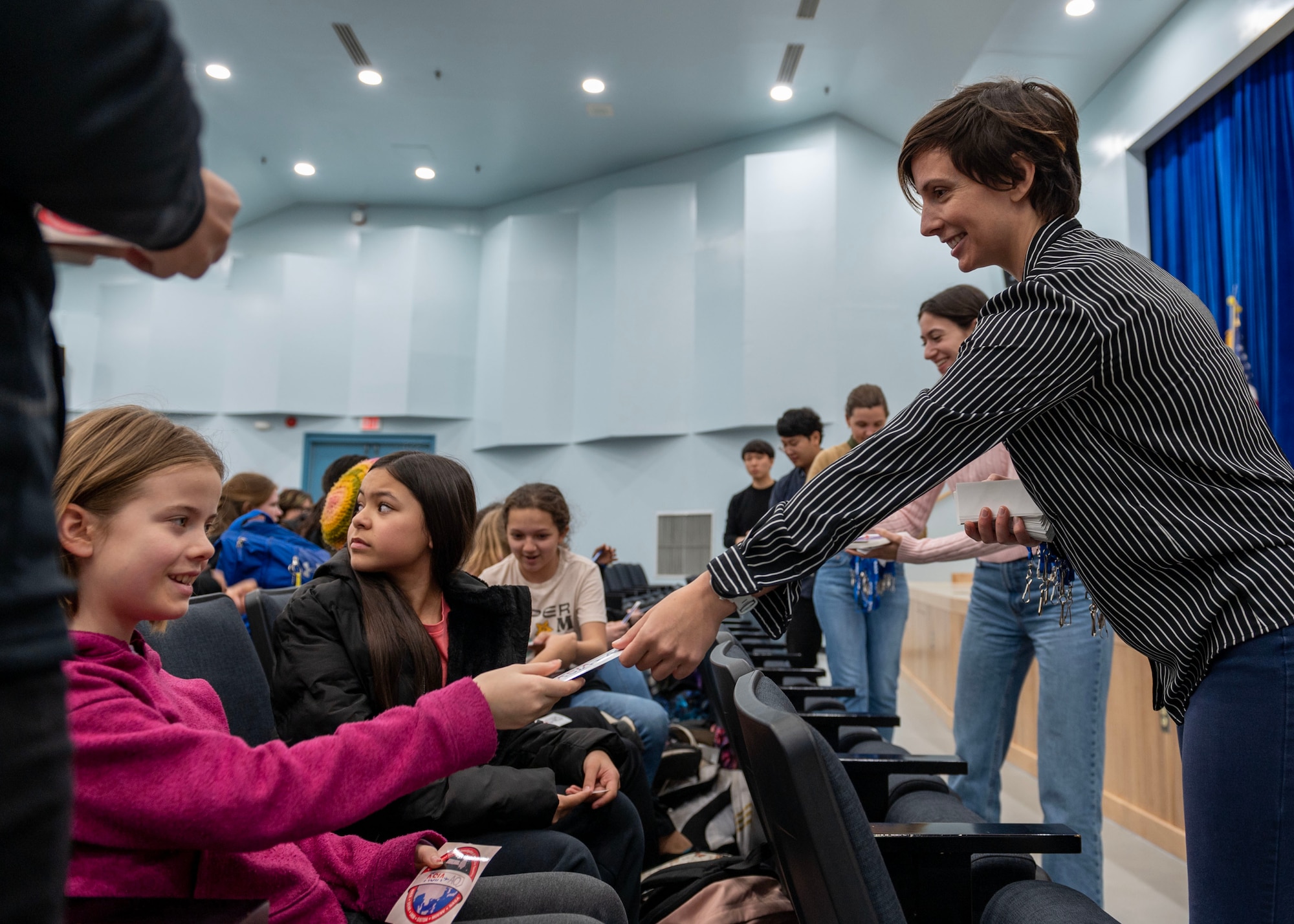 Dr. Brenna Biggs, NASA airborne science program science communications lead, hands a NASA sticker to a student during the Airborne and Satellite Investigation of Asian Air Quality, or ASIA-AQ, student engagement event at Osan Air Base, Republic of Korea, Feb. 20, 2024. During the ASIA-AQ campaign, an international cooperative field study designed to address local air quality challenges, an open house, student engagement and several research flights were conducted at Osan AB. (U.S. Air Force photo by Staff Sgt. Aubree Owens)