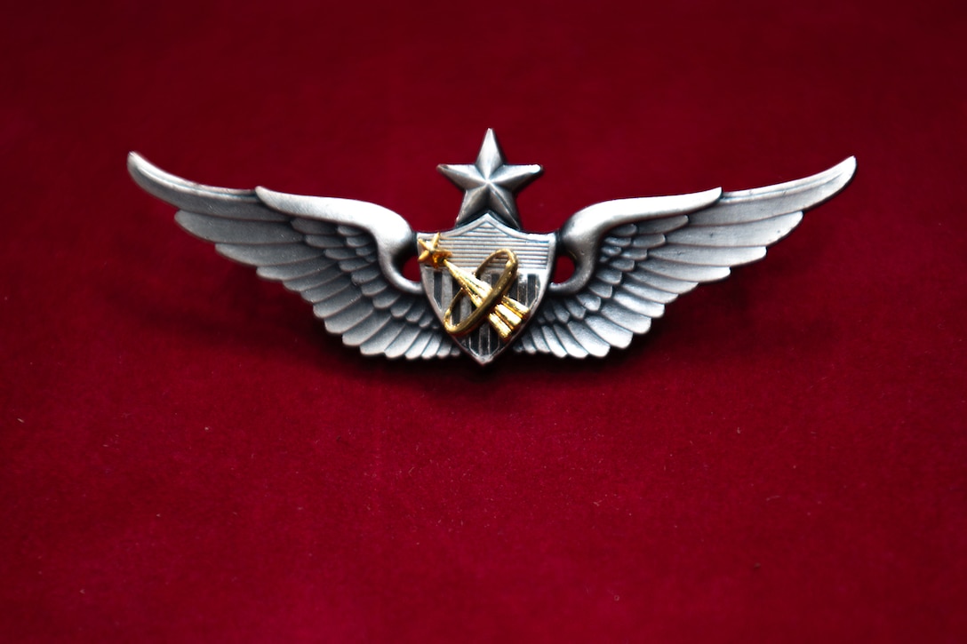 Close up of an Army aviation badge featuring wings, a star and a space emblem.