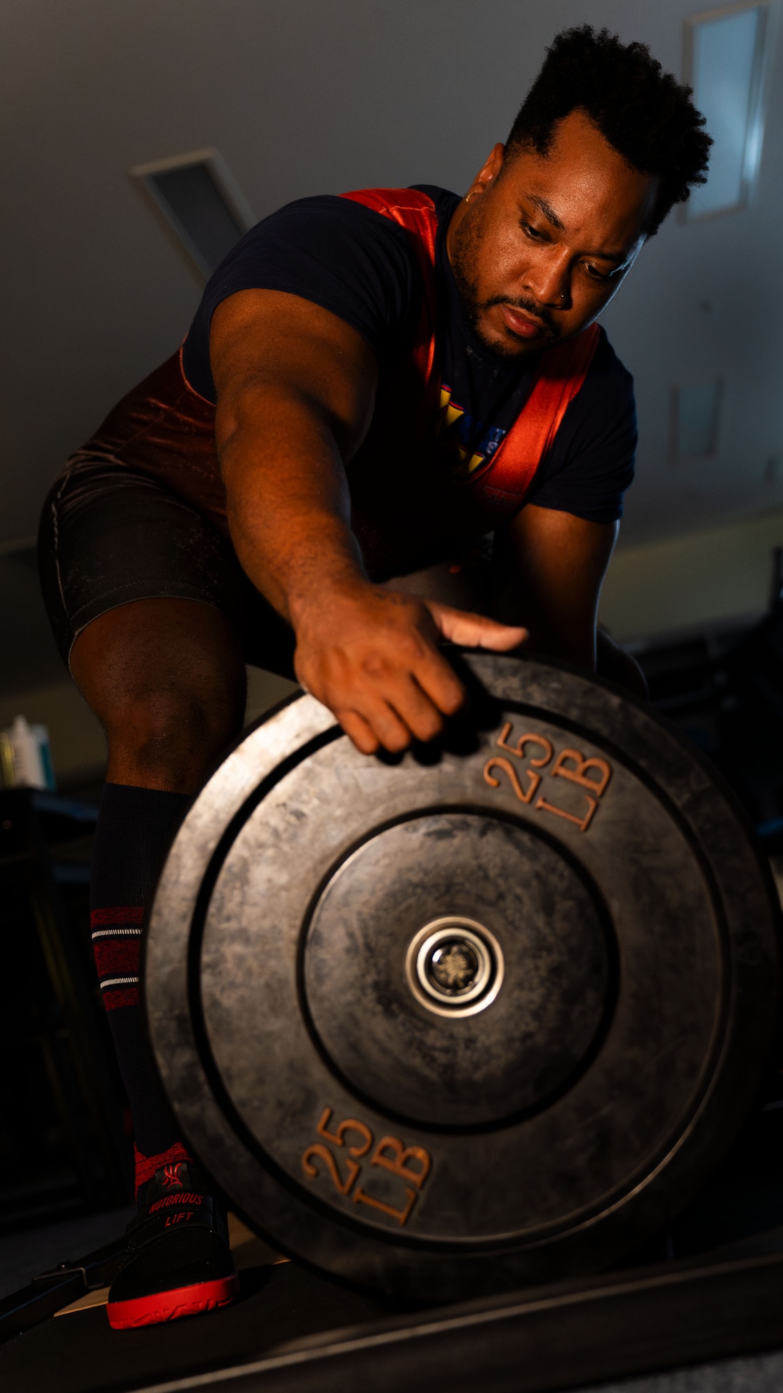 A man loads plates onto a barbell.