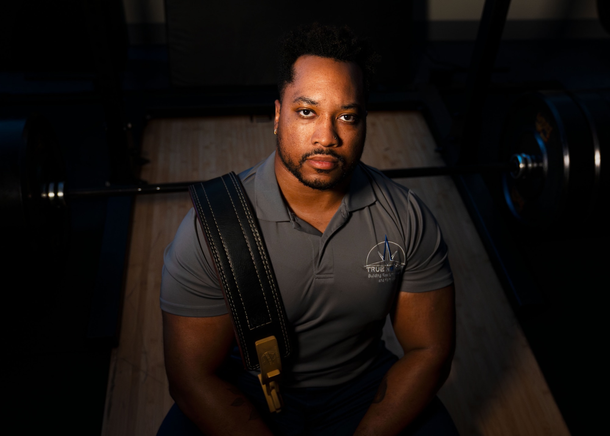 A man poses for a photo with weights.