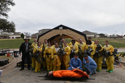 Members assigned to the 17th Medical Group pose for a picture following their Integrated in-place patient decontamination training at Goodfellow Air Force Base, Texas, Feb. 8, 2023. DECON training aims to inform first responders and hospital staff members, who would be the first to respond or provide care, and what steps need to be taken to ensure safety. (U.S. Air Force photo by 2nd Lt. Kayunna Holt)