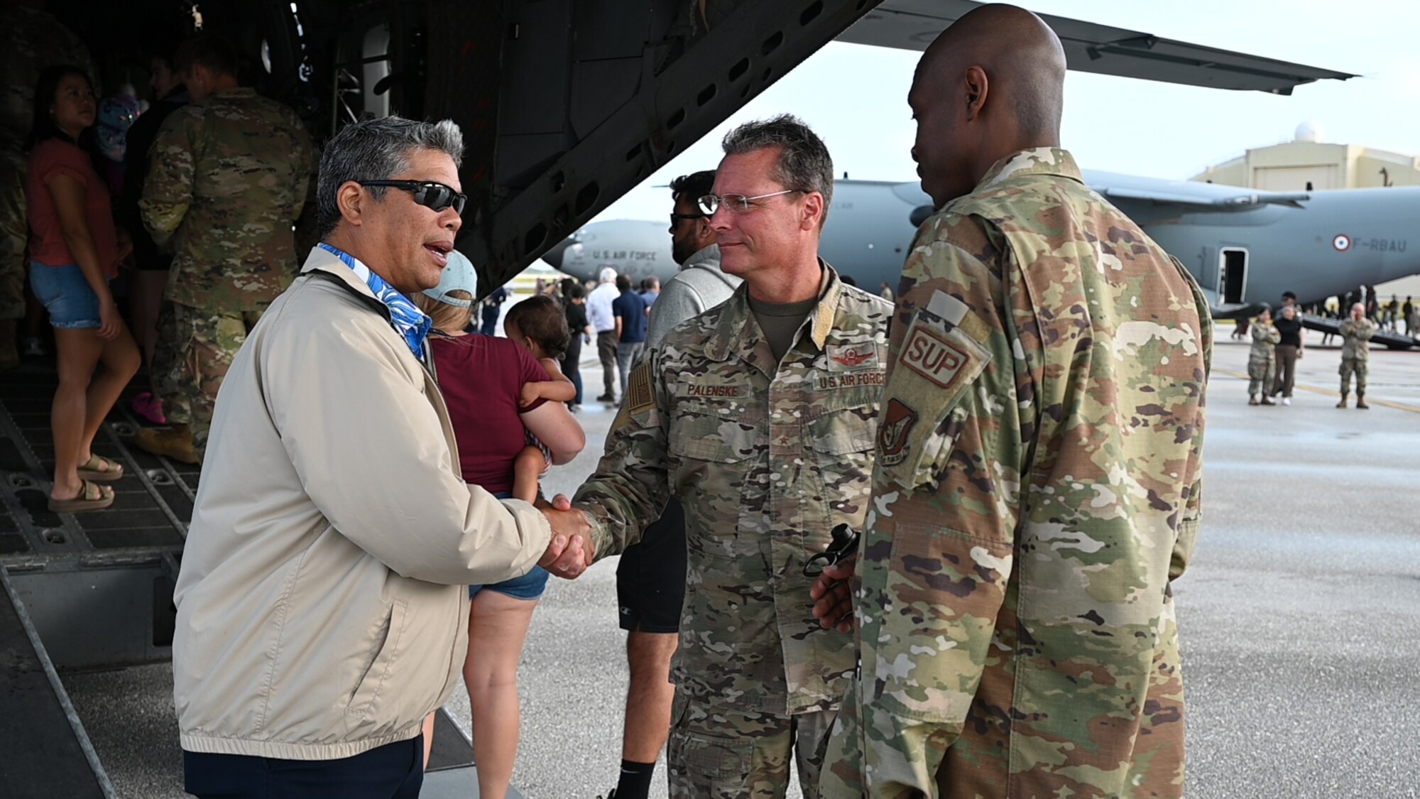 Two leaders from the 36th Wing shakes hands with visitors