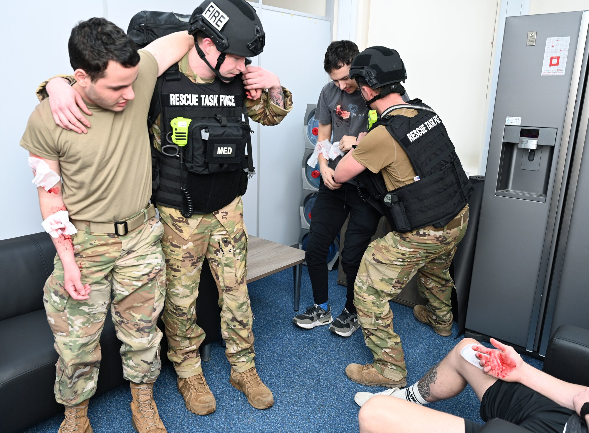 U.S. Air Force 100th Civil Engineer Squadron Fire Department rescue task force members assist simulated casualties during an exercise at Royal Air Force Mildenhall, England, Feb. 15, 2024. Airmen from squadrons around base volunteered to role-play as casualties and the active shooter to give a more realistic feel to the exercise and make it more visual for the first responders. The exercise was designed to evaluate the training, readiness and capability of RAF Mildenhall first responders to effectively respond to active shooter threats on the installation. (U.S. Air Force photo by Karen Abeyasekere)