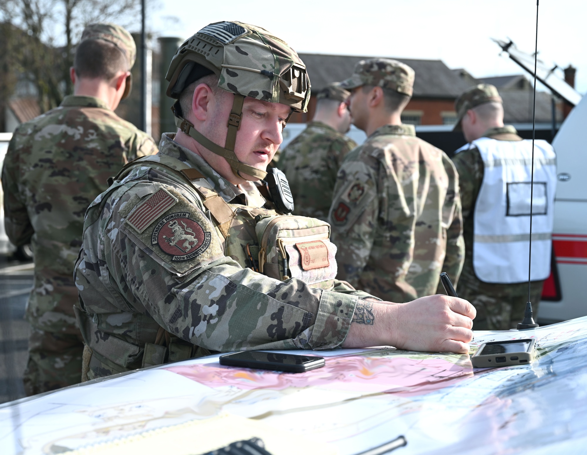 U.S. Air Force Tech. Sgt. Anthony Wentworth, 100th Security Forces Squadron flight sergeant, uses a base map to keep track of the location of 100th SFS Airmen during an active shooter exercise at Royal Air Force Mildenhall, England, Feb. 15, 2024. Airmen from squadrons around base volunteered to play as casualties and the active shooter to give a more realistic feel to the exercise and make it more visual for the first responders. The exercise was designed to evaluate the training, readiness and capability of RAF Mildenhall first responders to effectively respond to active shooter threats on the installation. (U.S. Air Force photo by Karen Abeyasekere)