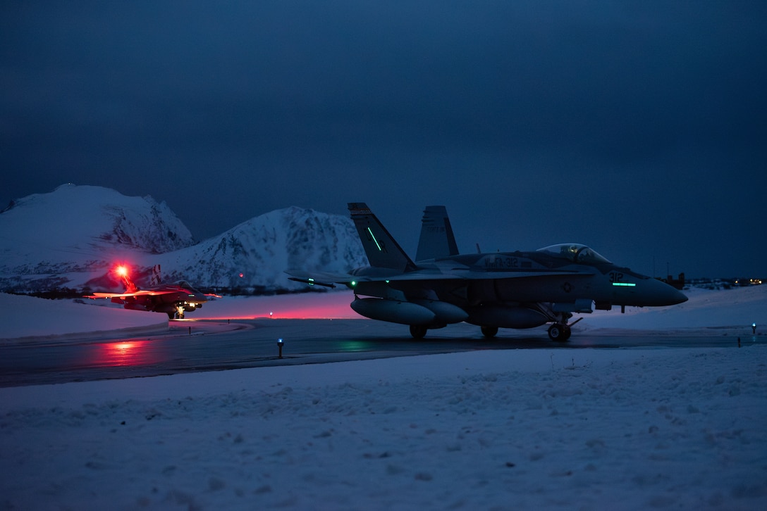 Two U.S. Marine Corps F/A-18 Hornet aircraft, assigned to Marine Fighter Attack Squadron (VMFA) 312, 2nd Marine Aircraft Wing, taxi on a runway after landing in preparation for Exercise Nordic Response 24 at Andenes, Norway, Feb. 21, 2024. Exercise Nordic Response, formerly known as Cold Response, is a NATO training event conducted every two years to promote military competency in arctic environments and to foster interoperability between the U.S. Marine Corps and allied nations. (U.S. Marine Corps photo by 2nd Lt. Duncan Stoner)