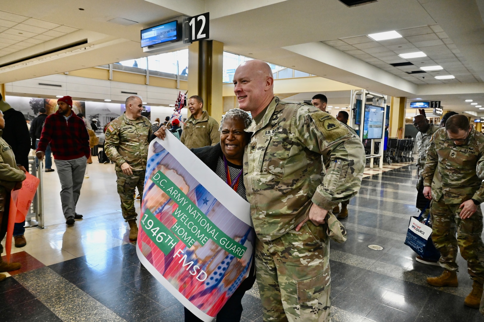 Soldiers with the 1946th Financial Management Support Detachment, District of Columbia National Guard, are greeted by family, friends, senior leadership and D.C. National Guard Family Programs reps at Ronald Reagan Washington National Airport, Feb. 16, 2024. Guard members returned from a nine-month deployment to Camp Bondsteel, Kosovo, providing financial management support to Kosovo Forces assigned to the NATO peacekeeping mission.