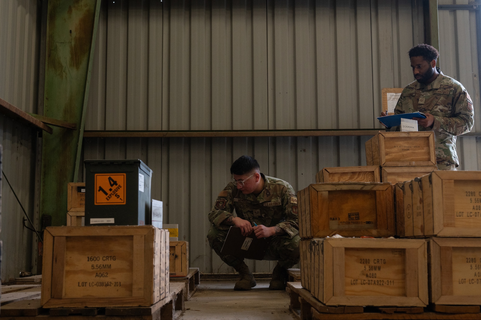 Two male airman are doing inventory.