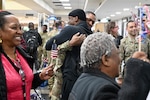 Soldiers with the 1946th Financial Management Support Detachment, District of Columbia National Guard, are greeted by family, friends, senior leadership and D.C. National Guard Family Programs reps at Ronald Reagan Washington National Airport, Feb. 16, 2024. Guard members returned from a nine-month deployment to Camp Bondsteel, Kosovo, providing financial management support to Kosovo Forces assigned to the NATO peacekeeping mission.