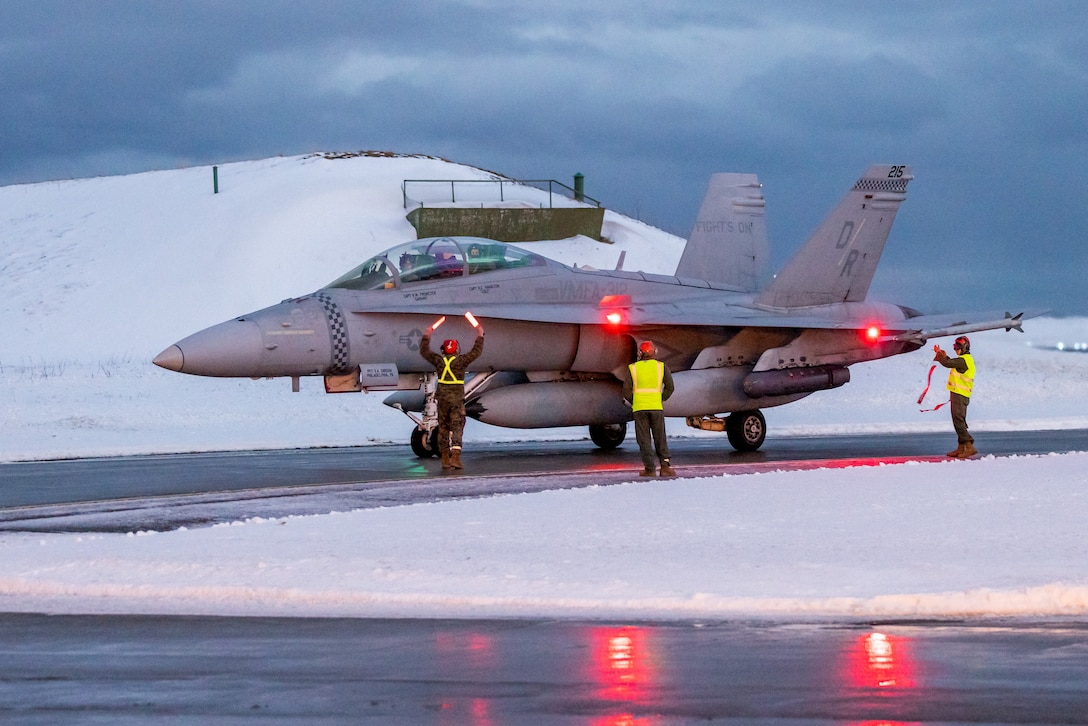 U.S. Marines with Marine Fighter Attack Squadron (VMFA) 312, 2nd Marine Aircraft Wing, conduct flightline operations as an F/A-18D Hornet aircraft lands in preparation for Exercise Nordic Response 24 at Andenes, Norway, Feb. 21, 2024. Exercise Nordic Response, formerly known as Cold Response, is a NATO training event conducted every two years to promote military competency in arctic environments and to foster interoperability between the U.S. Marine Corps and allied nations. (U.S. Marine Corps photo by Cpl. Christopher Hernandez)