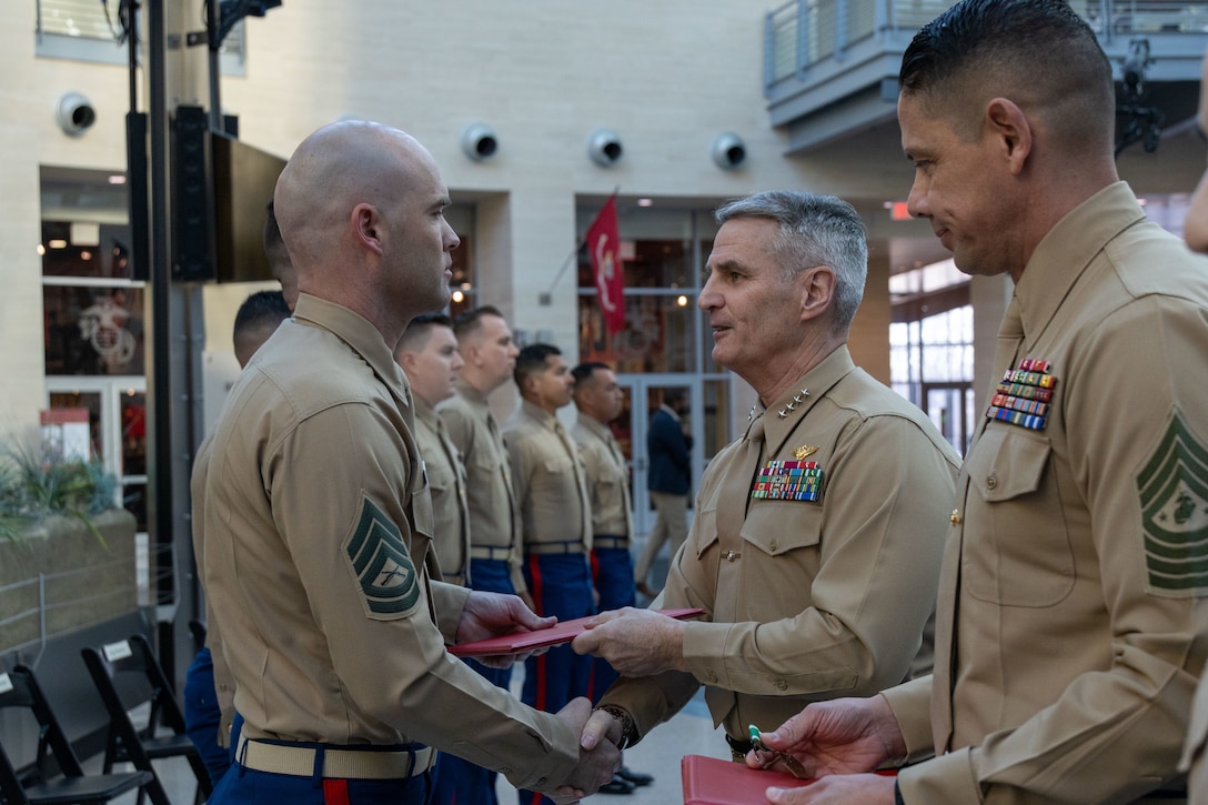 U.S. Marine Corps Gunnery Sgt. Russell B. Cowan, left, a recruiter with Recruiting Station San Diego, Calif., 12th Marine Corps District, receives the award for Recruiter of the Year from General Christopher J. Mahoney, the 37th Assistant Commandant of the Marine Corps, at the National Museum of The Marine Corps, Triangle, Va., February 8, 2024. The award was given to recognize the best of those who scour the nations landscape seeking out those who will take their place upon the yellow footprints. (U.S. Marine Corps photo by Sgt. Rachaelanne Woodward)