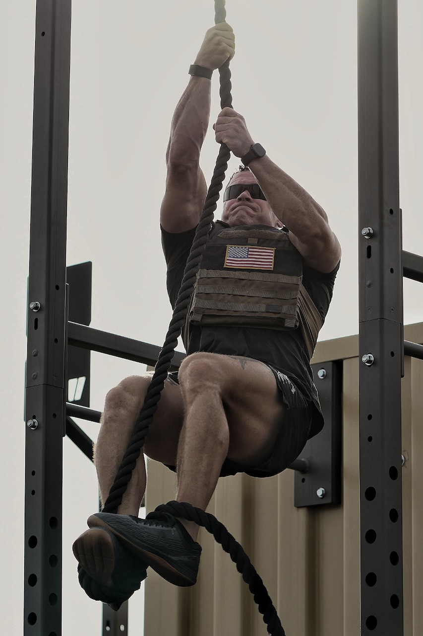A soldier climbs a rope.