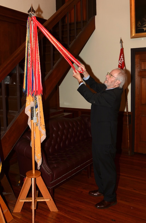 Dennis Boylan, an honorary captain who served as First Troop Philadelphia City Cavalry’s commander from 1983 to 1988, displays some of the battle streamers on the troop's colors inside the troop's armory in Philadelphia. (Pennsylvania National Guard photo by Brad Rhen)