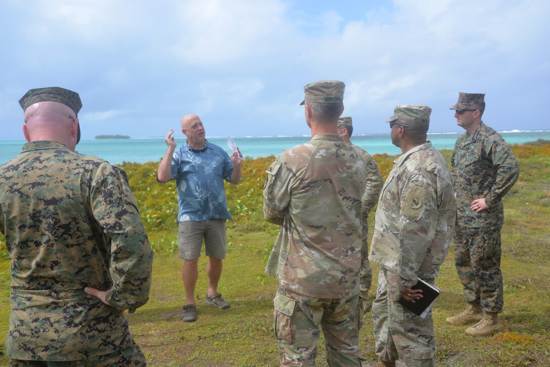 Timothy Francis explaining how 4th Marine Division conducted a lagoon landing left of Jacob Island (background). Author photo.
