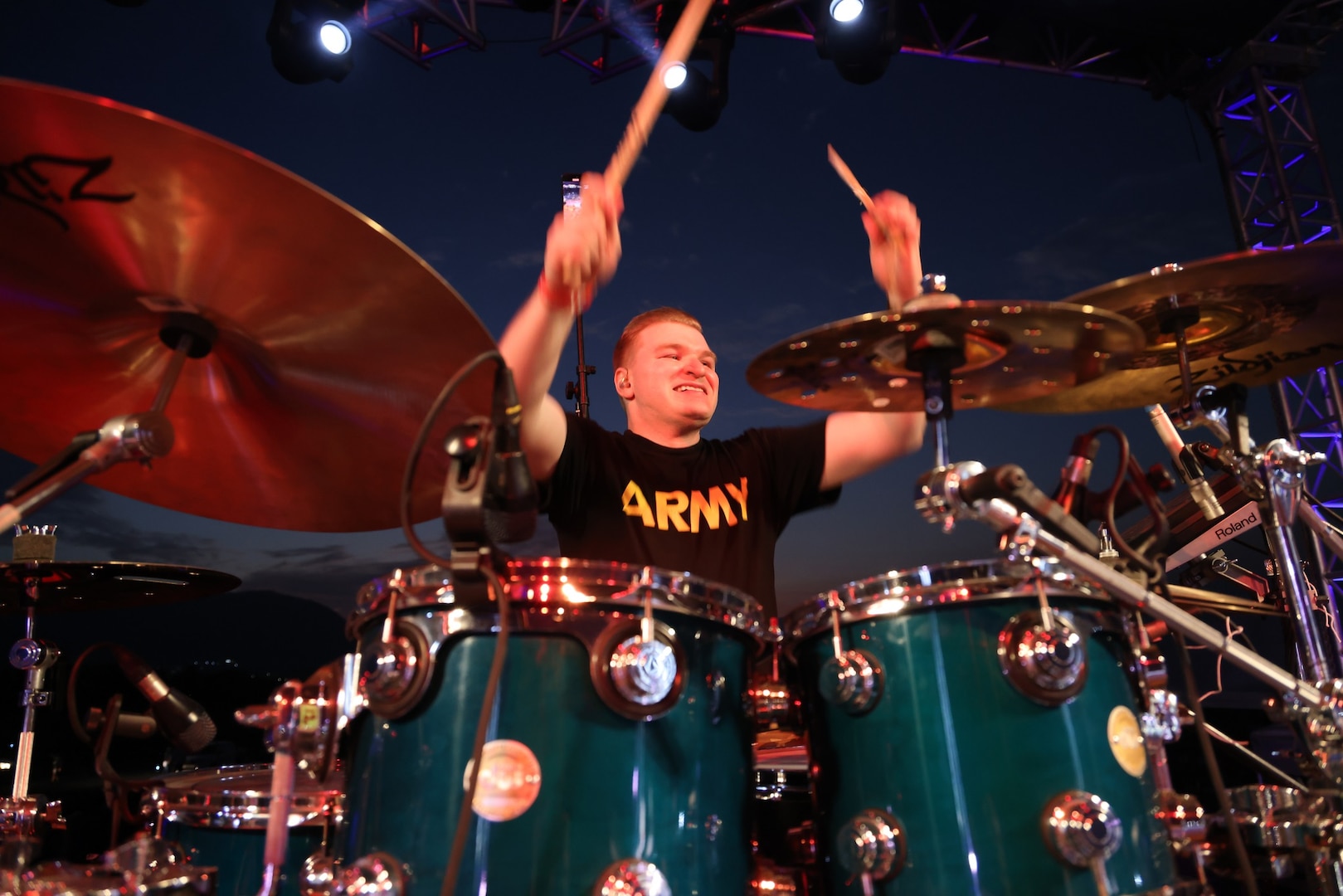 Sgt. 1st Class David Selmer, drummer and production director for the 39th Army Band, 54th Troop Command, New Hampshire Army National Guard, plays the opening beat of the band's cover of “We Will Rock You,” by Queen at the Ilopango Air Show in El Salvador on Feb. 18, 2024.