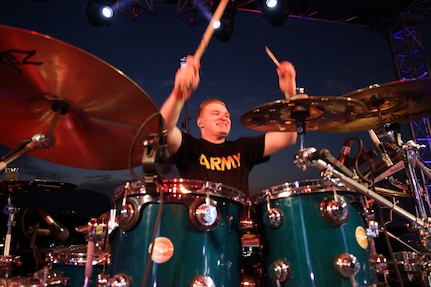 Sgt. 1st Class David Selmer, drummer and production director for the 39th Army Band, 54th Troop Command, New Hampshire Army National Guard, plays the opening beat of the band's cover of “We Will Rock You,” by Queen at the Ilopango Air Show in El Salvador on Feb. 18, 2024.