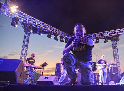 1st Sgt. Gregg Chapman, vocalist and senior enlisted advisor for the 39th Army Band, 54th Troop Command, New Hampshire Army National Guard, amps up the crowd during the band's opening cover of “Shut Up and Dance” by Walk the Moon at the Ilopango Air Show in El Salvador on Feb. 18, 2024.