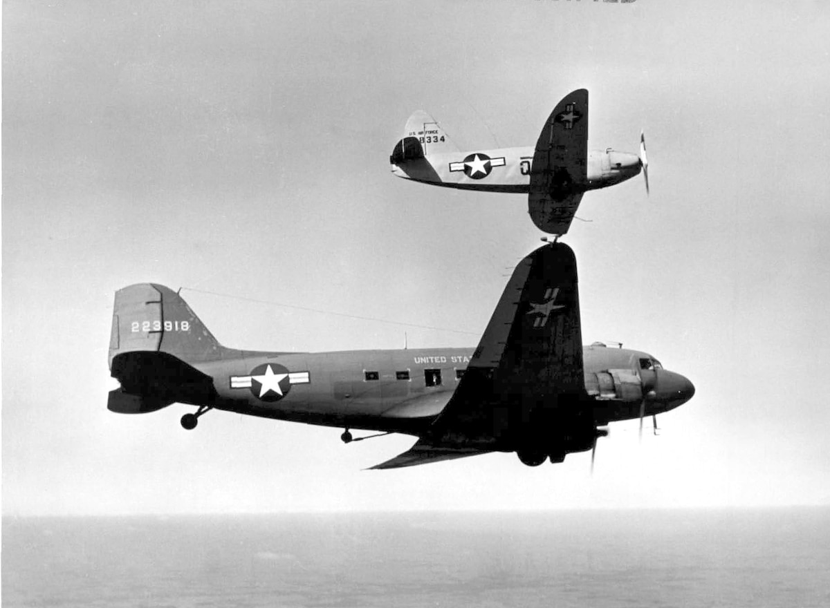 A small Q-14B Cadet attached to the right wing of the C-47A host aircraft during testing out of Wright Field, OH.