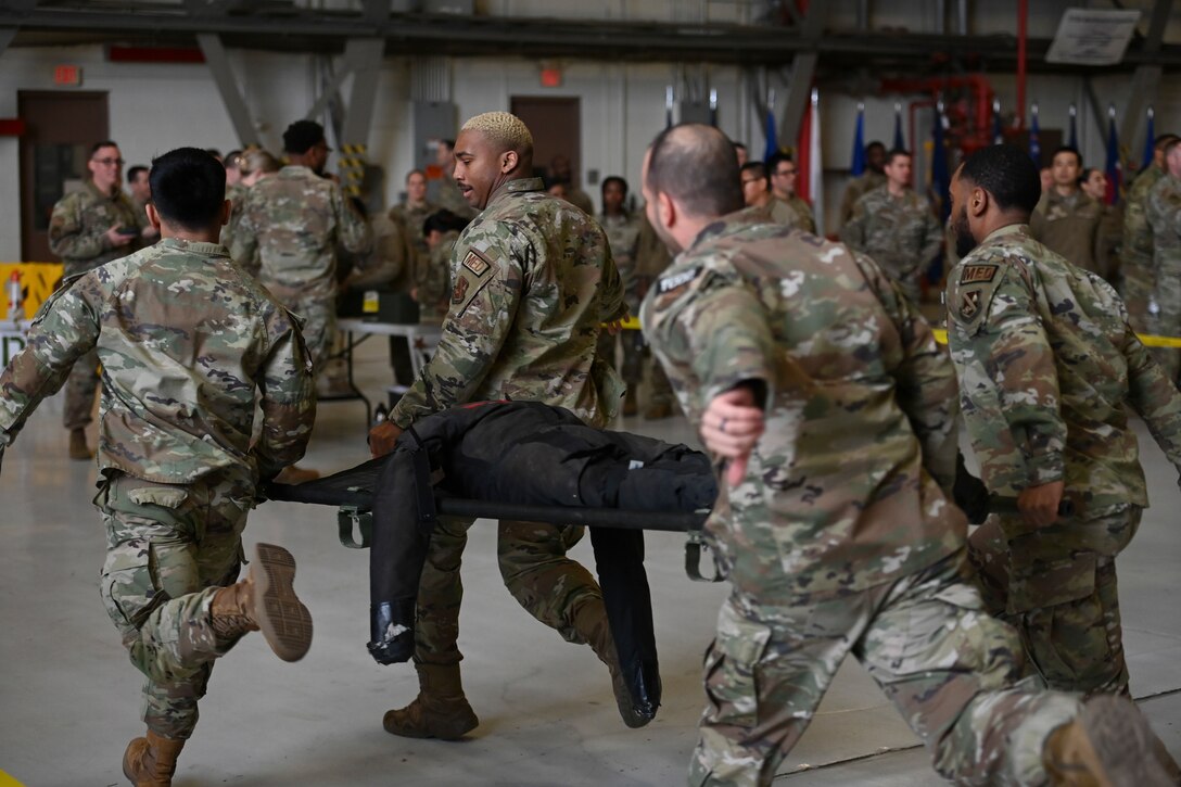 Military members running a medical manikin during competition.