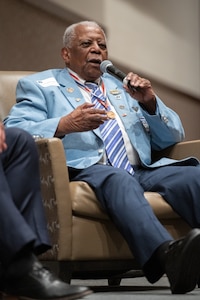 Tuskegee Airman speaks into a microphone during the Accelerating the Legacy event at Joint Base Charleston, South Carolina, Feb. 16, 2024.