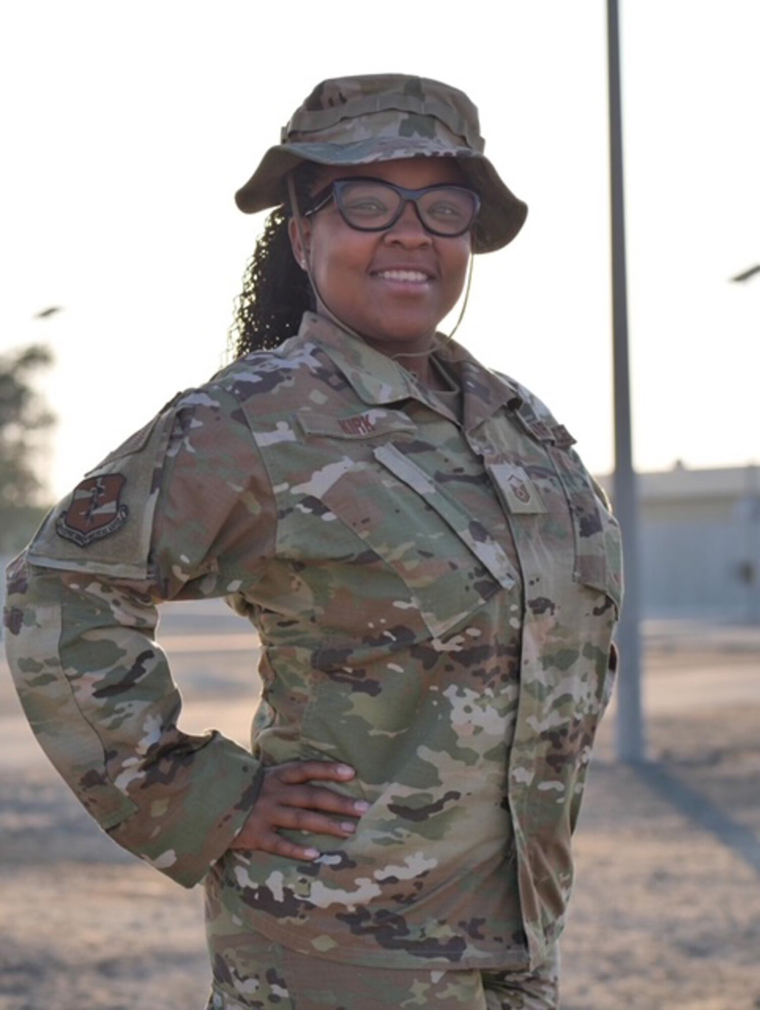 Air Force Airman poses for a photo while on deployment. She is wearing an OCP pattern uniform and boonie hat.