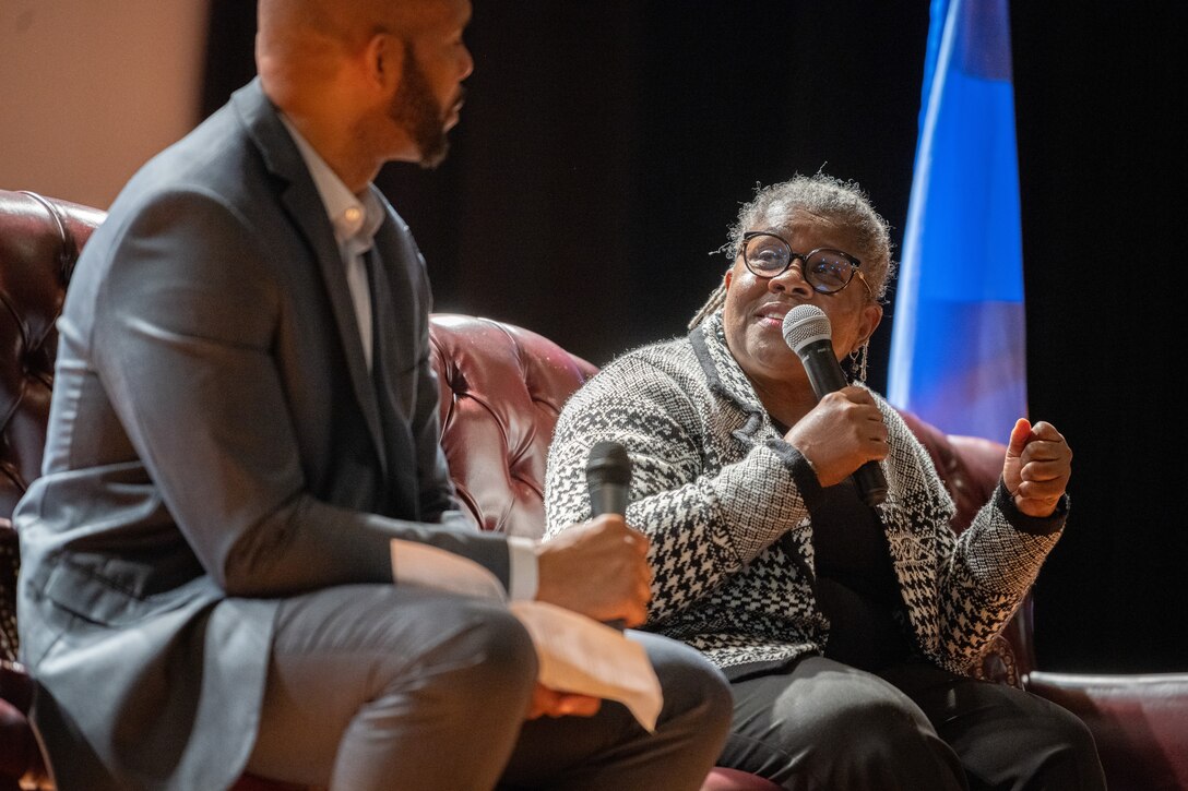 Retired U.S. Air Force Maj. Theresa M. Claiborne, the first African American woman to become an Air Force pilot, speaks into a microphone during the Accelerating the Legacy event at Joint Base Charleston, South Carolina, Feb. 16, 2024.