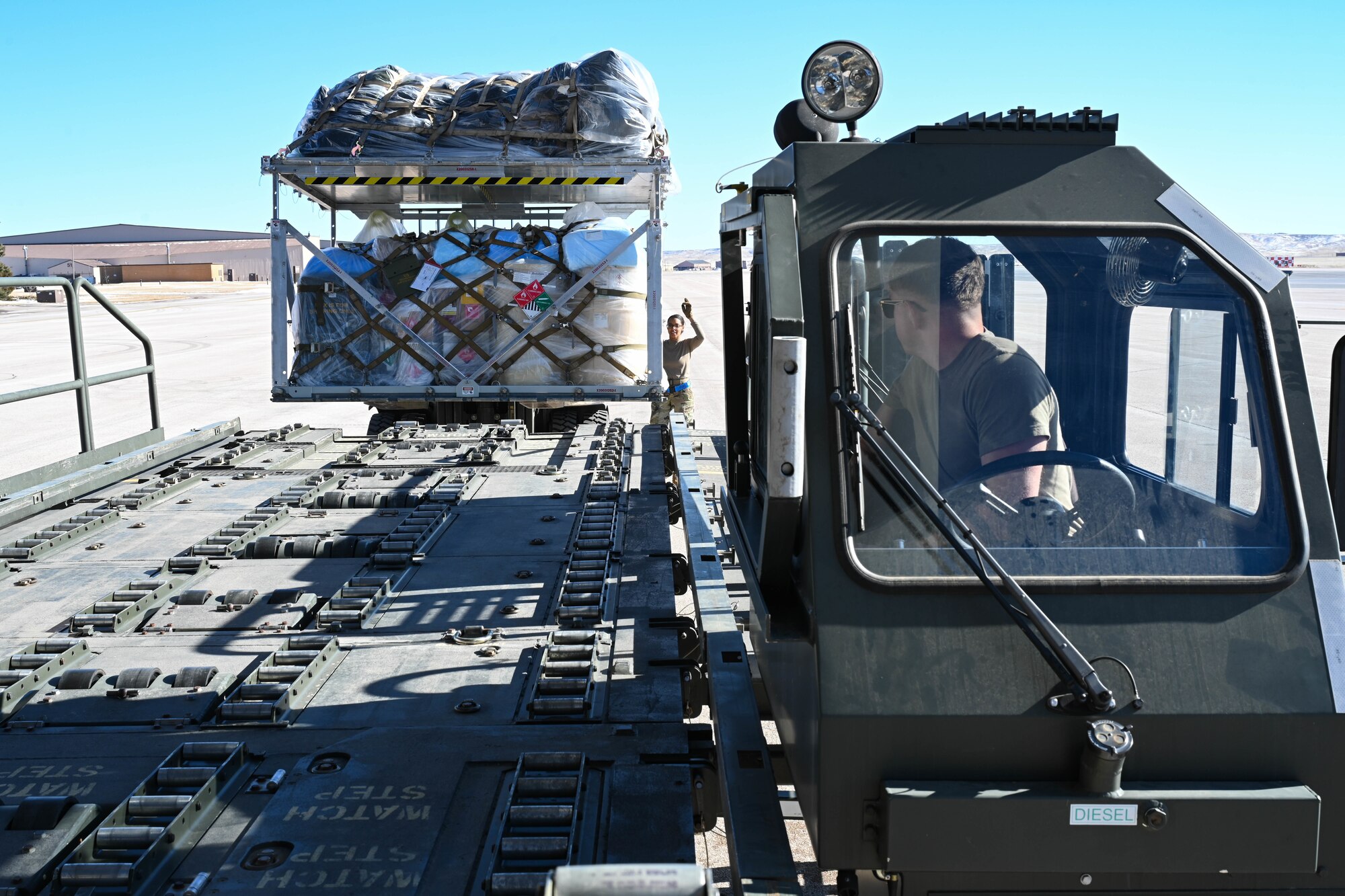 Airman 1st Class Hunter Corcoran, left, 28th Logistics Readiness Squadron air transportation technician, operates an aircraft cargo loader vehicle to transport cargo onto a C-17 Globemaster III, at Ellsworth Air Force Base, South Dakota, Feb. 19, 2024. Bomber Task Force missions enhance the readiness and training necessary to respond to any potential crisis or challenge across the globe. (U.S. Air Force photo by Airman 1st Class Dylan Maher)