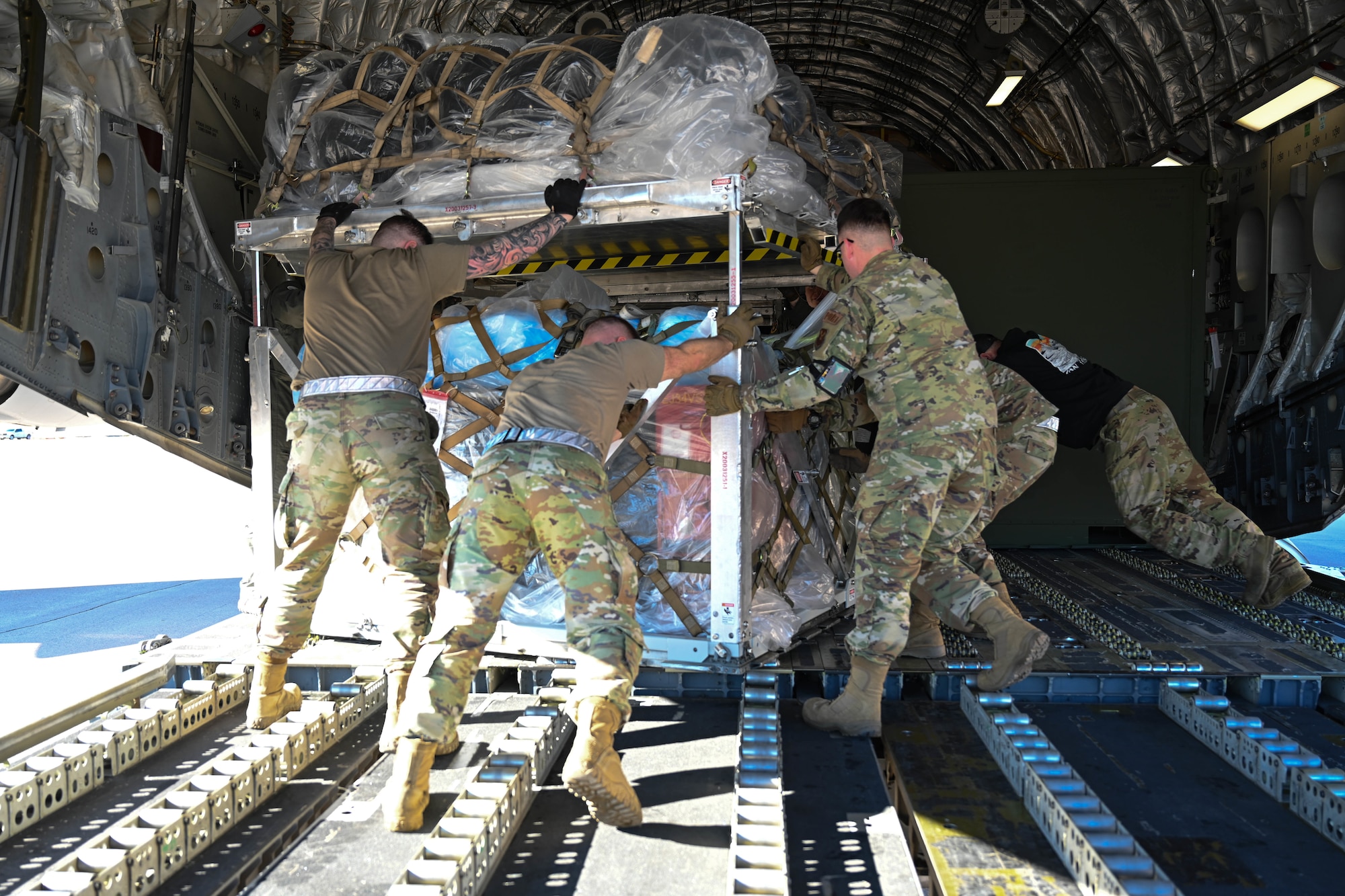 Aircrew members from the 758th Airlift Squadron and ground crew members from the 28th Logistics Readiness Squadron position vertically stacked cargo onto the bay of a C-17 Globemaster III at Ellsworth Air Force Base, South Dakota, Feb. 19, 2024. In support of operational readiness, the 28th LRS coordinated with the 758th Airlift Squadron from Scott Air Force Base, Illinois to implement and execute vertical pallet stacking in order to maximize cargo space. (U.S. Air Force photo by Airman 1st Class Dylan Maher)