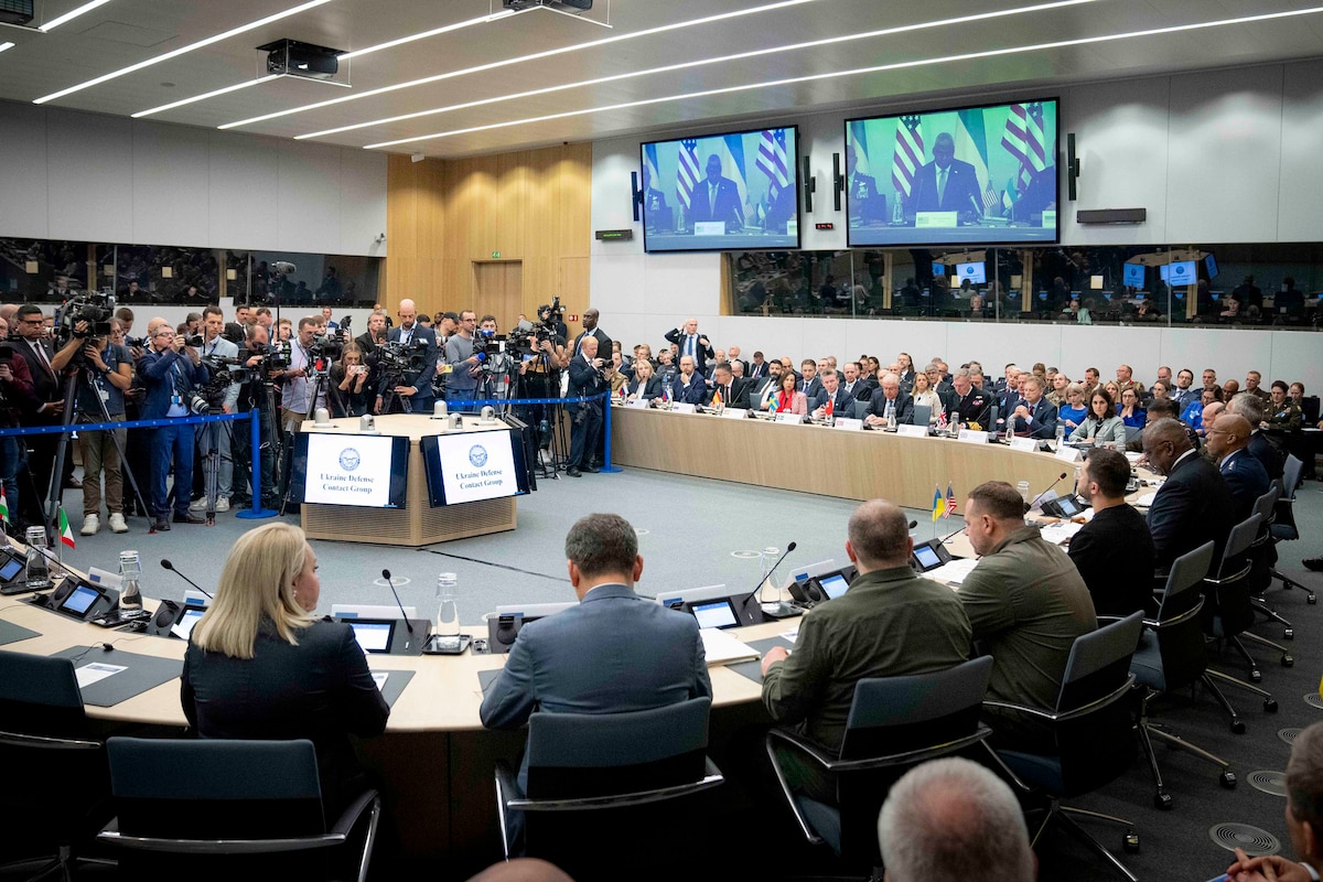 Officials sit around a large U-shaped table.