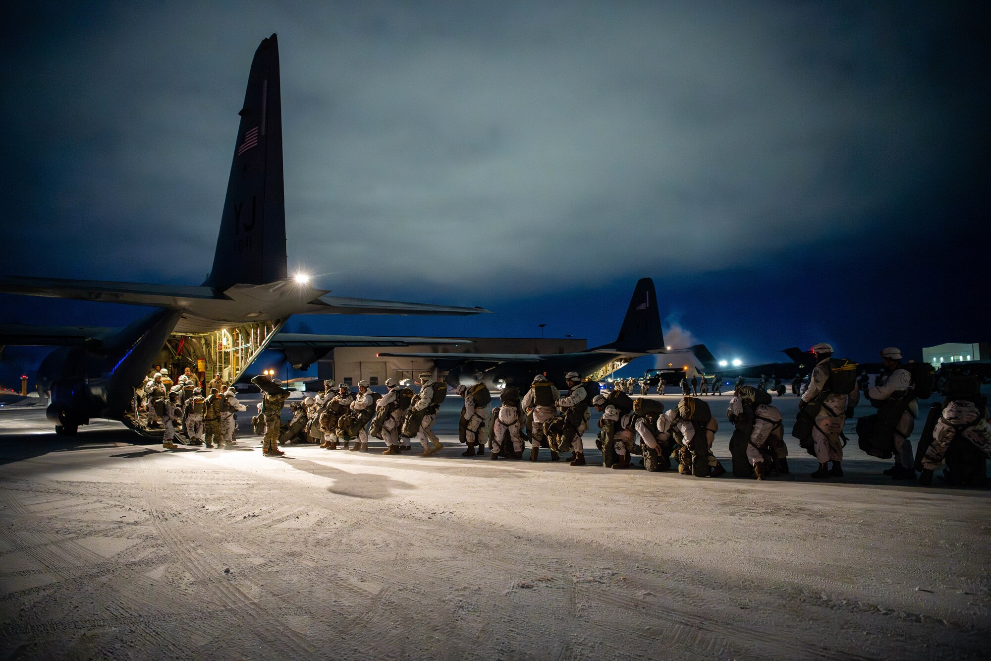 Paratroopers from the U.S. Army 2nd Infantry Brigade Combat Team, 11th Airborne Division, board a C-130J Super Hercules in preparation for a joint forcible entry exercise during Joint Pacific Multinational Readiness Center 24-02 at Joint Base Elmendorf-Richardson, Alaska.