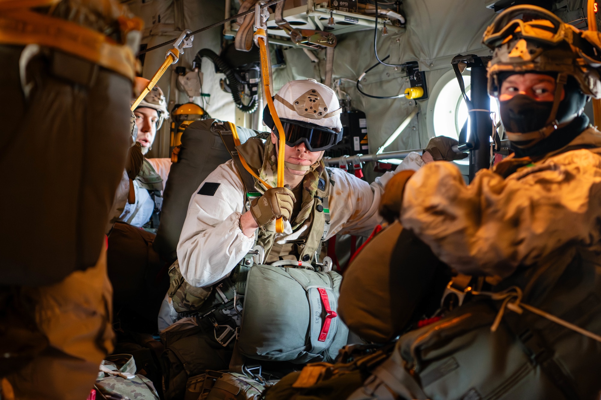 Paratroopers from the U.S. Army 2nd Infantry Brigade Combat Team, 11th Airborne Division, stand under the static line of a C-130J Super Hercules prior to conducting an airborne assault as part of a joint forcible entry exercise during Joint Pacific Multinational Readiness Center 24-02 in Alaska.