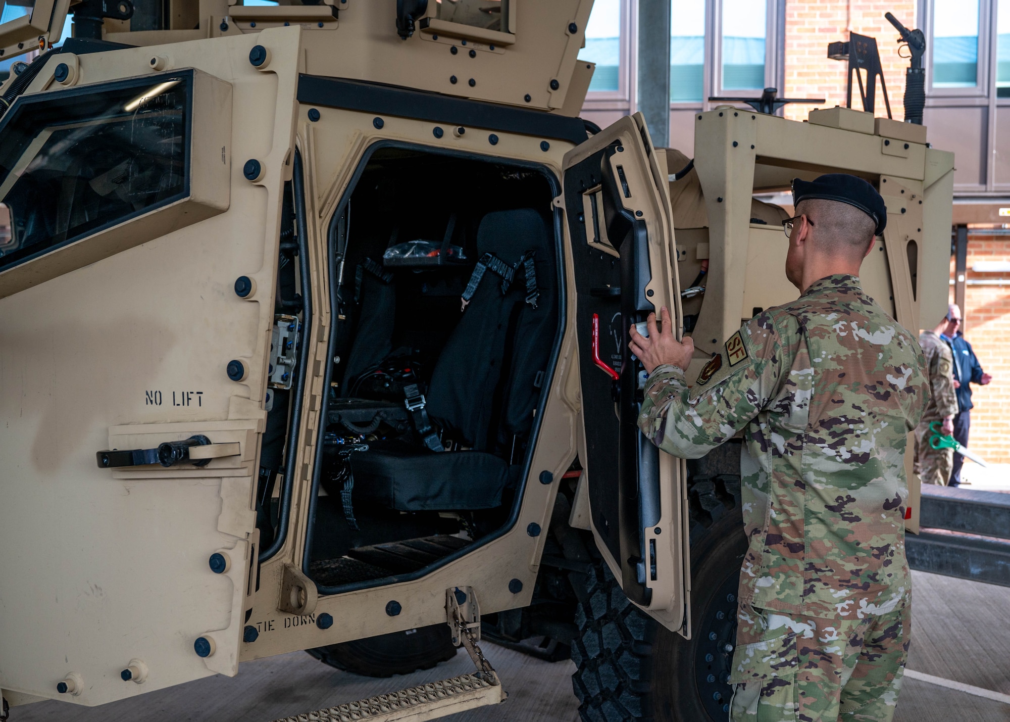 A U.S. military members opens the door of a new vehicle