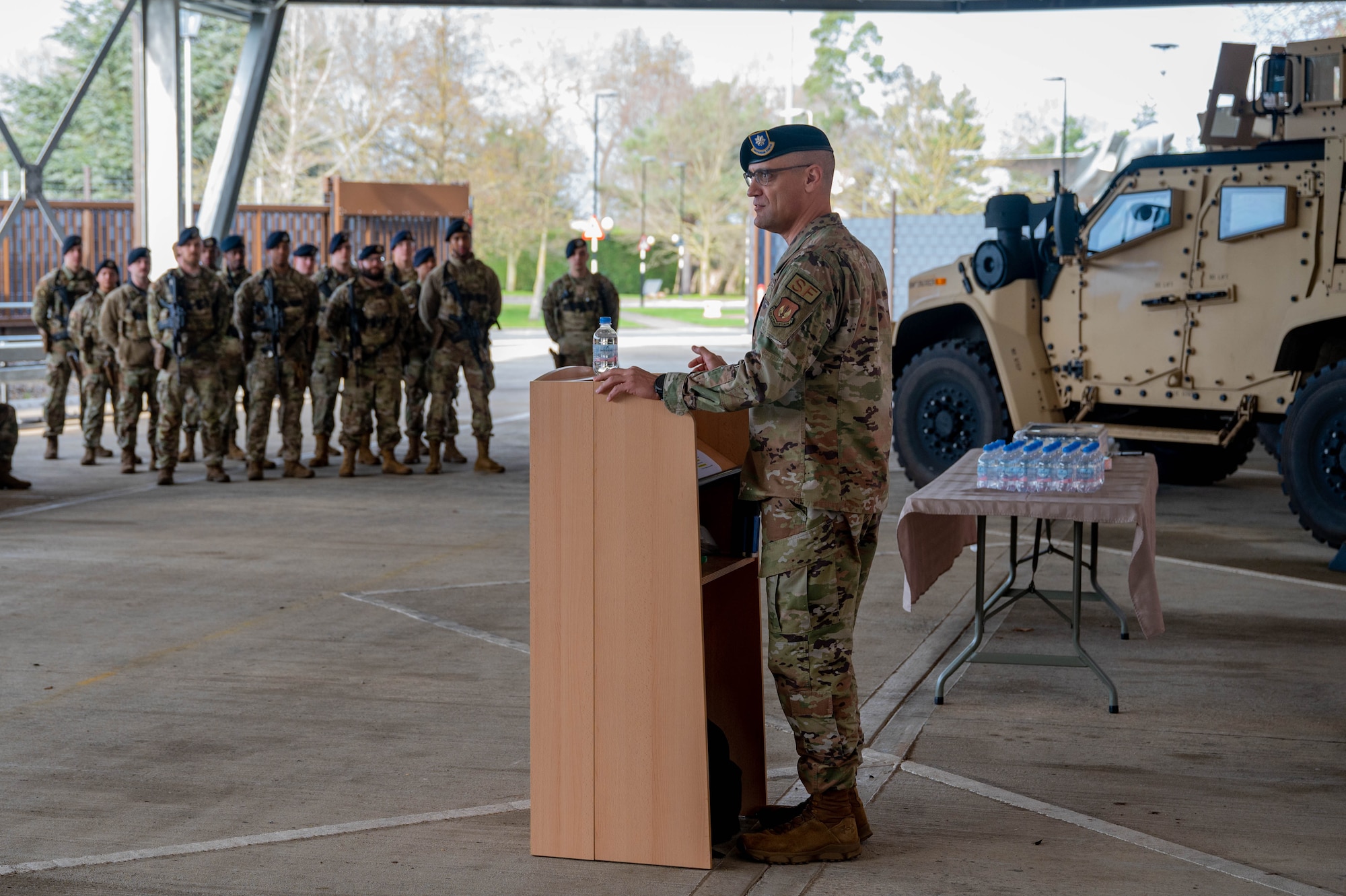 A U.S. military member speaks at a podium to a crowd of people during an event