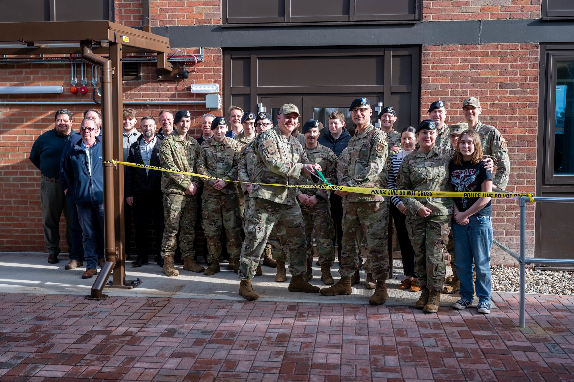 U.S. military members cut a ribbon with scissors in front of a new facility