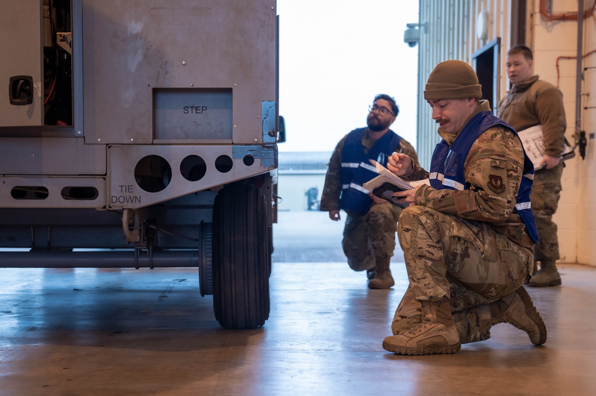 A U.S. military member writes on a checklist while processing cargo