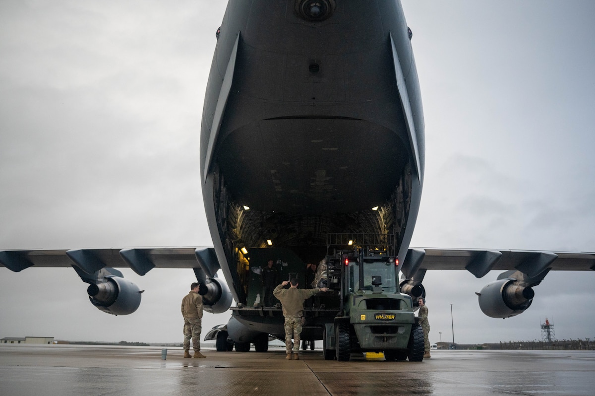 U.S. military members load cargo onto an aircraft