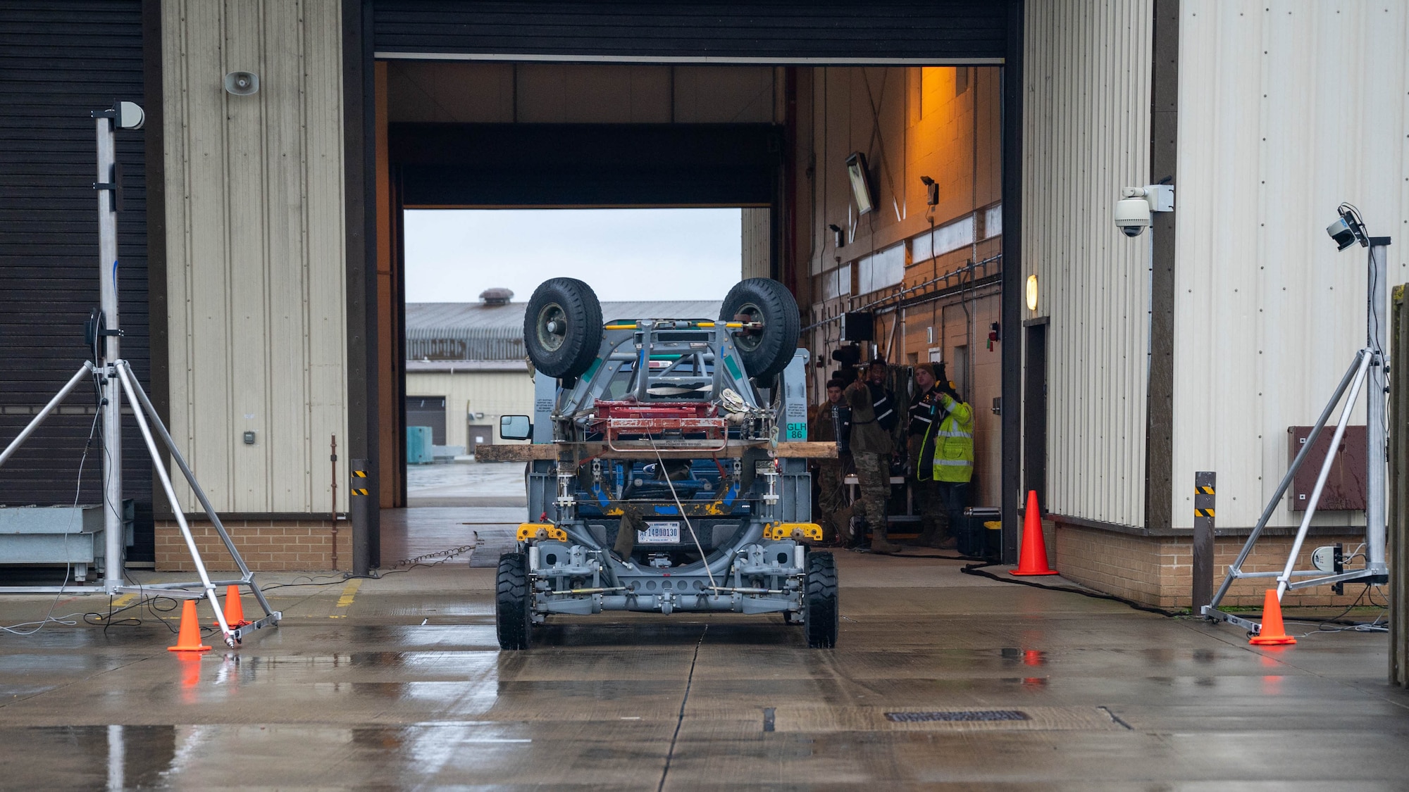 A vehicle drives through a hangar on a military installation
