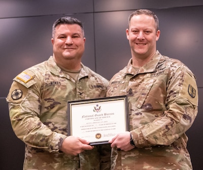 Col. Shawn Nokes, Commander, 129th Regiment (Regional Training Institute) presents Sgt. Maj. Kevin Driscoll, 129th RTI’s operations sergeant major, with a Certificate of Service from the National Guard Bureau during Driscoll’s retirement ceremony Feb. 24 at the Illinois Military Academy, Camp Lincoln in Springfield, Illinois.