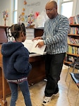 Stanley Jones providing direct mentorship and teaching a child how to read music and play the piano.