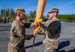 Army Col. Jeremey Davis (left) receives the colors for the 50th Regional Support Group (RSG) from Army Maj. Gen. Robert Carruthers (right), assistant adjutant general – Army and commander of the Florida Army National Guard, during a change of command ceremony in Homestead, Florida, on Jan. 21, 2024. Davis accepting the colors is symbolic of assuming his new position as RSG commander. (U.S. Army Guard photo by Sgt. 1st Class Shane Klestinski.)