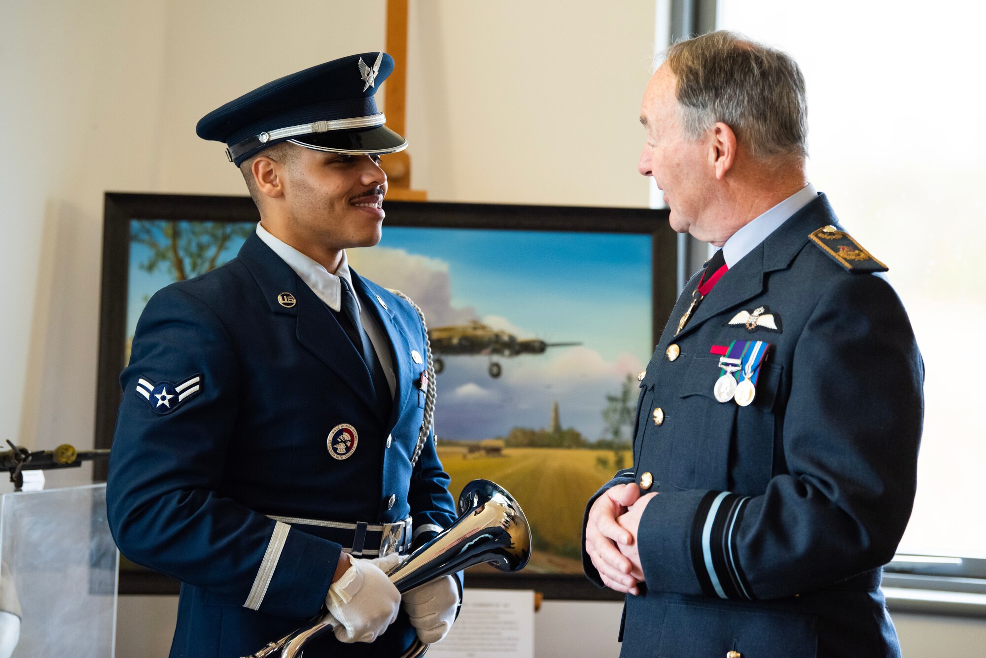 An Airman from the 501st Combat Support Wing Honor Guard speaks with Air Vice-Marshal Andrew White CB DL, after a Ceremony of Remembrance at Stanwick Lakes, England, Feb. 22, 2024. U.S. and U.K. leaders gathered to honor 17 Airmen who died in a midair collision on Feb. 22, 1944, involving B-17 Flying Fortresses from the 303rd Bombardment Group at RAF Molesworth and the 384th Bombardment Group at RAF Grafton Underwood. The Airmen were part of Operation Argument, or "The Big Week," targeting enemy industrial sites and aircraft facilities in Central Europe to secure Allied air superiority for the upcoming landings in France in June 1944. (U.S. Air Force photo by Staff Sgt. Jennifer Zima)