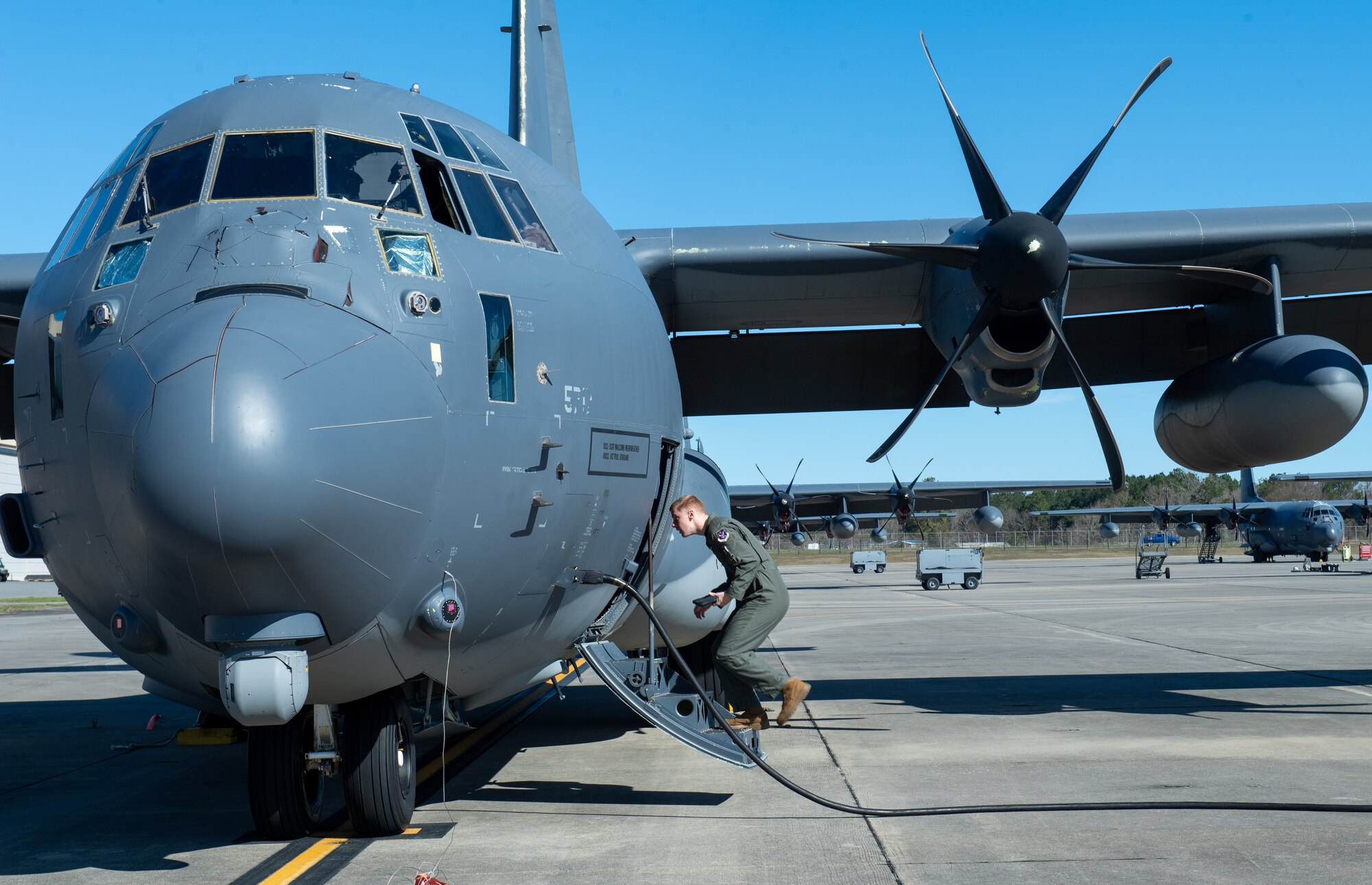 A crew member loads a C-130