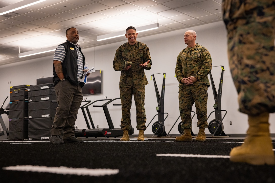 Raymond E. Anderson, left, director of strength and conditioning with Marine Corps Community Services, U.S. Marine Corps Sgt. Maj. Carlos A. Ruiz, center, Sergeant Major of the Marine Corps and Sgt. Maj. Ryan A. Gnecco, sergeant major, Marine Corps Installations East-Marine Corps Base (MCB) Camp Lejeune, exchange remarks in the future Warrior Athlete Readiness and Resilience Center, currently under construction, on MCB Camp Lejeune, North Carolina, Feb. 22, 2024. This facility will house a holistic, collaborative program that will enhance combat readiness in conjunction with warfighter resiliency by strengthening the mental, social, spiritual, and physical fitness necessary to overcome any challenge. (U.S. Marine Corps photo by Lance Cpl. Loriann Dauscher)