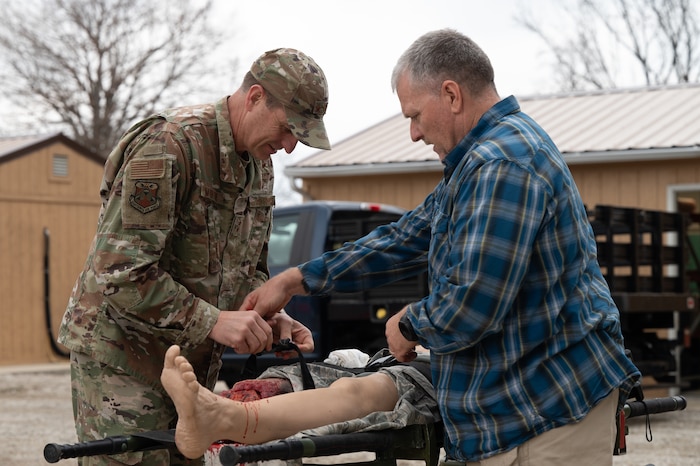 Maj. Gen. Corey Martin applies a tourniquet to a bleeding manikin with the assistance of Clyde Nobles
