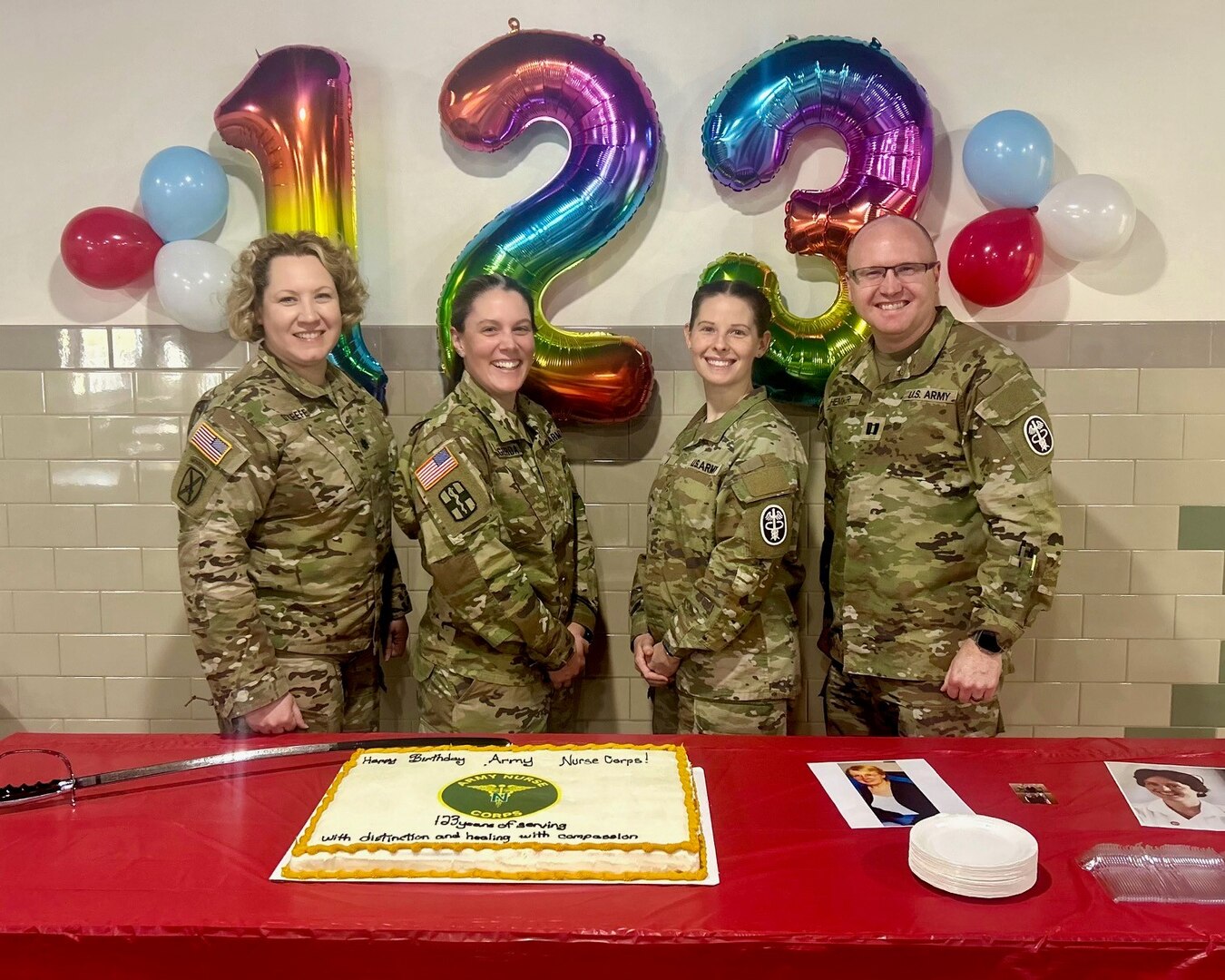 Four Army Nurse Corps Officers standing in front of a birthday cake celebrating the ANC Birthday