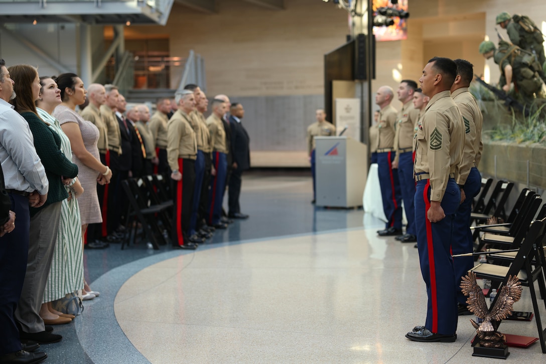 U.S. Marines stand at attention for the Marines’ Hymn during the Fiscal Year 2023 Commandant’s Combined Awards Ceremony at the National Museum of the Marine Corps, Triangle, Virginia, Feb. 8, 2024. . The ceremony recognized and awarded eight Marines with the Navy and Marine Corps Commendation Medal for their exceptional performance in their respective special duty assignments.  (U.S. Marine Corps photo by Lance Cpl. David Brandes)