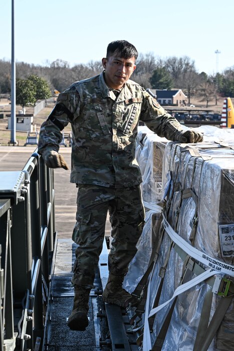 A man in uniform stands next to cargo