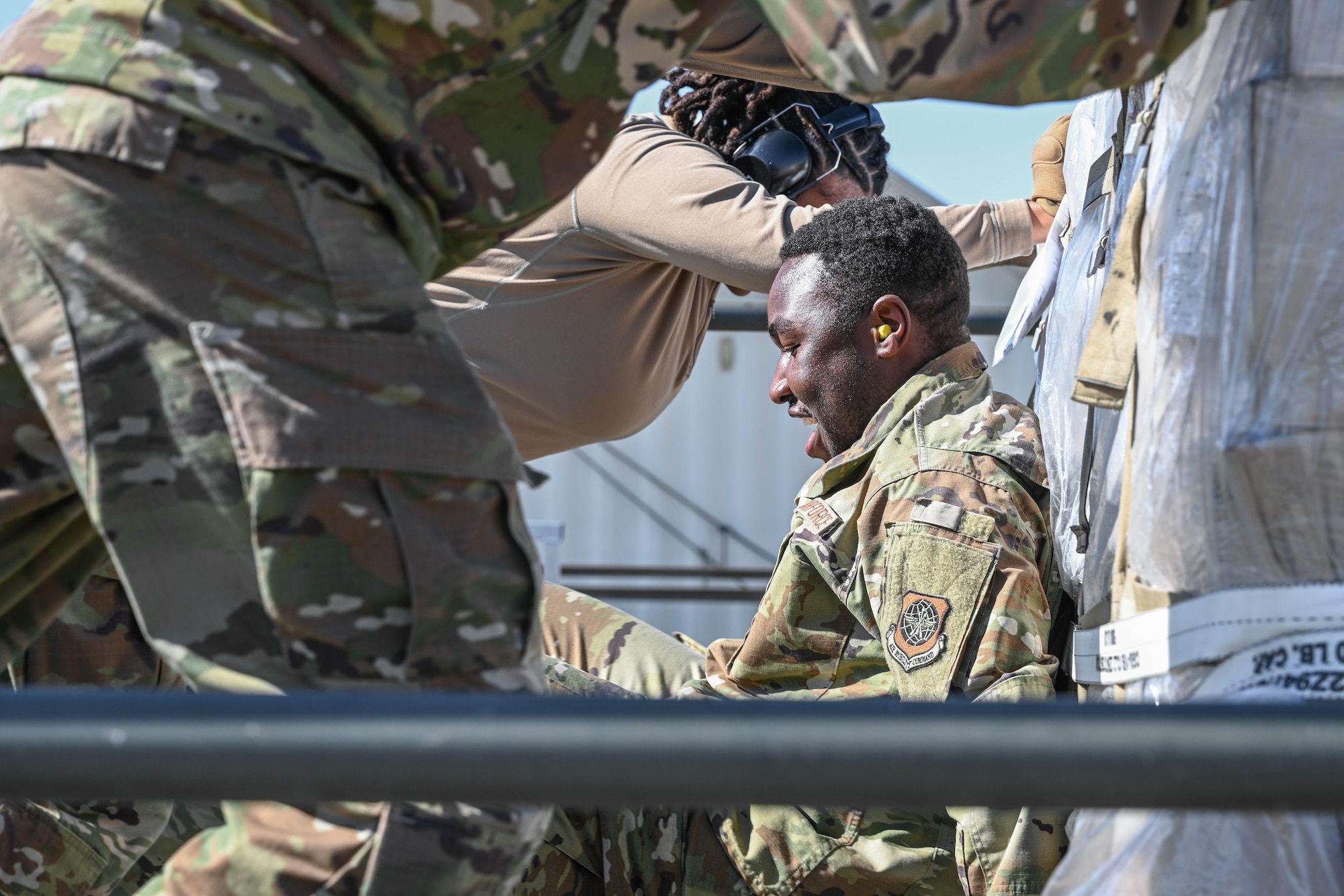 A man in uniform pushes cargo with his back