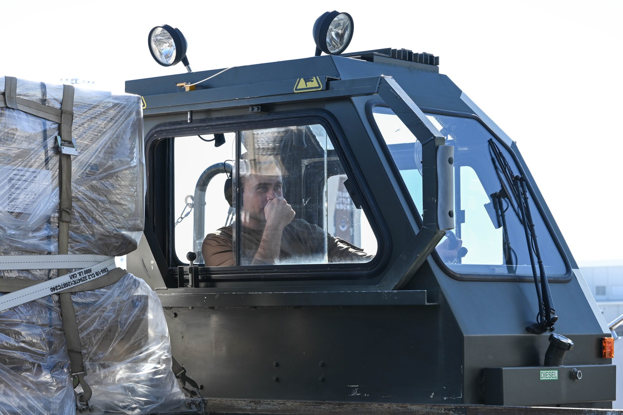 A man in uniform sits in the driver seat of a vehicle