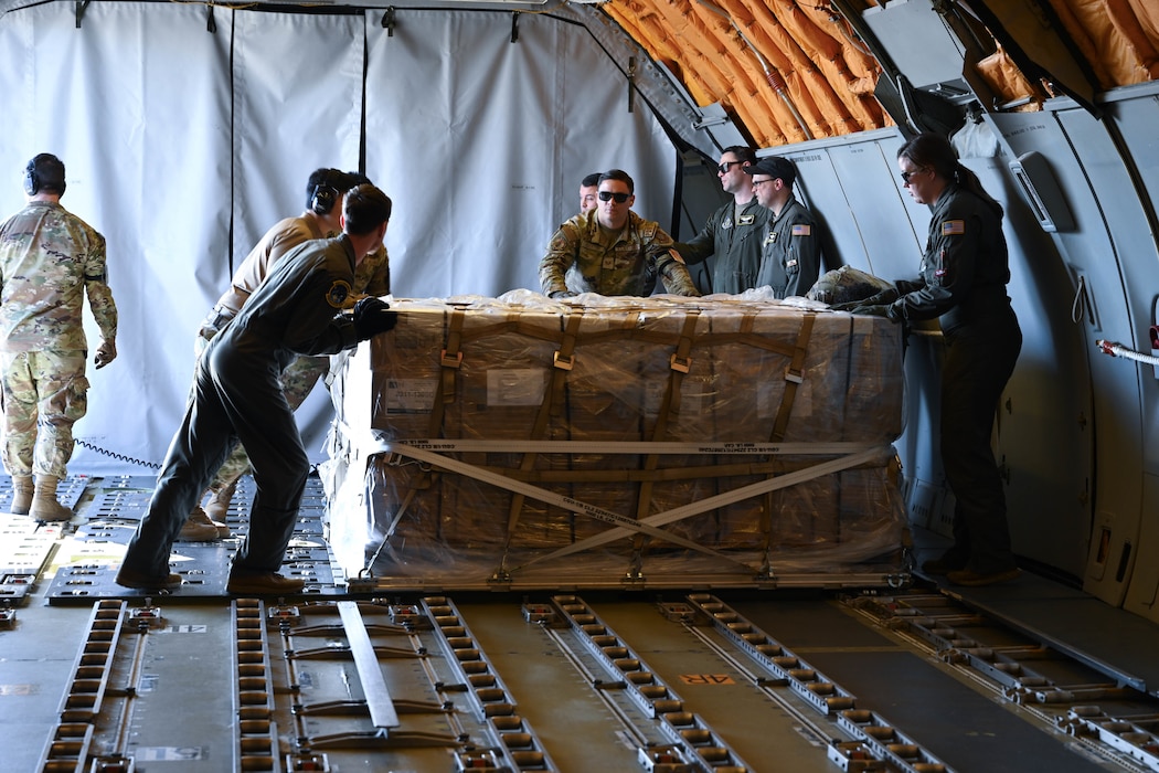 Men in uniform push cargo